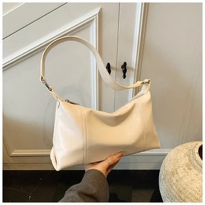Detail of creamy white faux leather shoulder bag with stylish vertical stitching texture