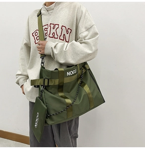Detail of army green nylon tote bag featuring a matching mini pouch and wide strap