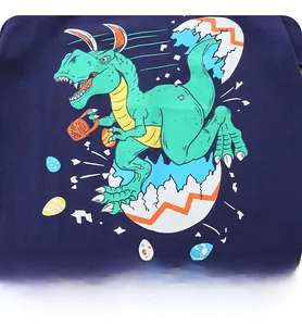 Close-up of Easter dinosaur print with bunny ears and eggs on navy cotton T-shirt