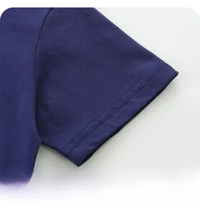 Macro dell'orlo a doppio ago su manica in cotone blu scuro con cuciture rifinite a mano