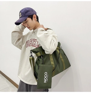Detail of olive green nylon tote bag featuring a detachable matching pouch and logo