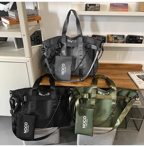 Detail view of large nylon tote bags in grey, black, and green with mini pouch and wide strap