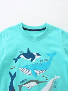 Mint green kids cotton T-shirt featuring ocean whale illustrations on a white background