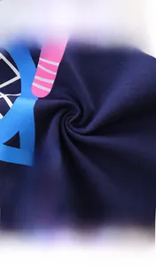 Close-up of 100% cotton knit fabric with colorful geometric prints on navy blue shirt
