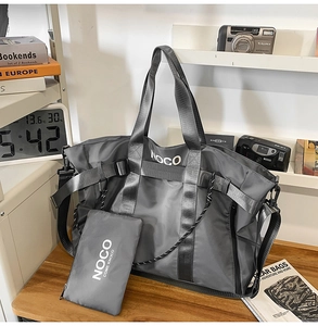 Detail of grey nylon tote bag with mini pouch and white NOCO logo on a wooden table