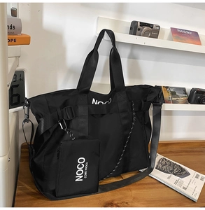 Detail of black nylon tote bag featuring a detachable small pouch with NOCO logo text