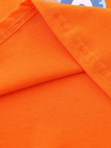 Detail of bright orange boys' cotton T-shirt featuring high-quality twin-needle stitching