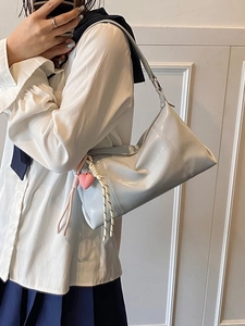 Light blue patent leather shoulder bag with pink heart charm shown in a mirror selfie