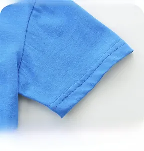 Gros plan sur l'ourlet de la manche du t-shirt bleu ciel avec des coutures à double aiguille