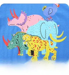 Gros plan sur un t-shirt bleu ciel pour garçons avec motifs de dinosaures et d'éléphants
