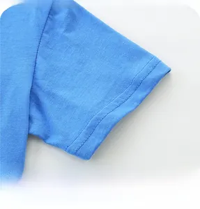 Gros plan de la couture double aiguille sur le poignet d'un T-shirt bleu en coton