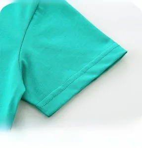 Close-up of sleeve stitching on children's green cotton t-shirt showing high quality seams