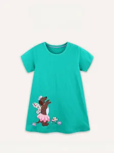 Détail d'une robe en coton vert avec broderie de chiot mignon et tutu rose