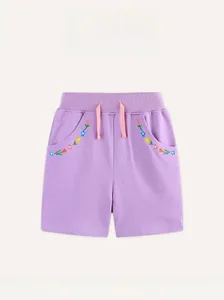 Detailweergave van paarse katoenen shorts met bloemenborduurwerk en decoratief koord