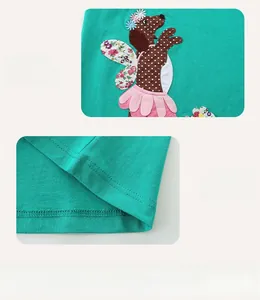 Détail de la broderie chiot et des coutures plates à double aiguille sur robe en coton vert