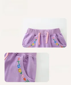 Detail van paarse katoenen meisjesshort met kleurrijk bloemeborduursel en elastische taille