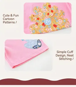 Close-up of girls' pink cotton shorts showing sunflower embroidery and neat hem stitching