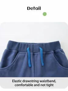 Detail of navy blue boys' cotton shorts showing elastic waistband and drawstring cords