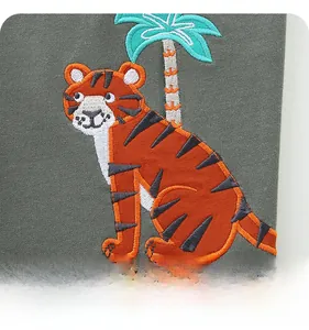 Detail of embroidered cartoon tiger and palm tree on boys' grey knit shorts