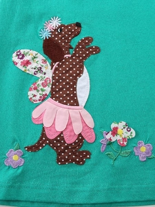 Gros plan sur l'applique de chien mignon sur robe en coton turquoise pour fille