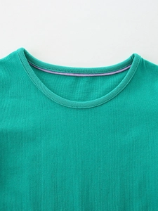 Détail de l'encolure de la robe verte pour filles avec bordure intérieure violette douce
