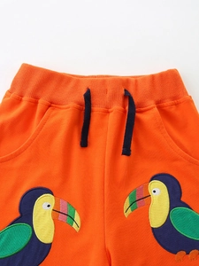 Vibrant orange boys sports shorts with elastic drawstring waist and colorful toucan embroidery
