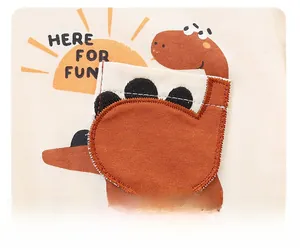 Detail of baby cotton knit outfit featuring 3D dinosaur pocket and Here For Fun text