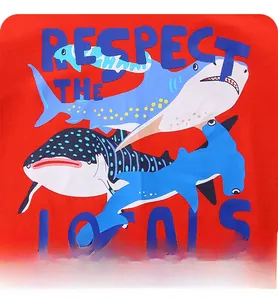 Close-up of shark prints and 'RESPECT THE LOCALS' text on red cotton boys' T-shirt