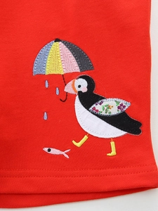 Girls red cotton shorts featuring detailed puffin and rainbow umbrella embroidery