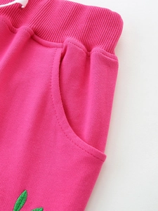 Rose red girls sports shorts featuring elastic waistband and green embroidery detail