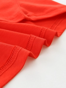 Detailed close-up of high-quality red cotton knit fabric with durable double-stitch seams