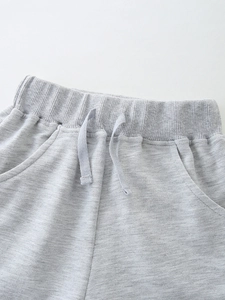 Kids grey knit cotton shorts with elastic waistband and drawstring detail in close-up