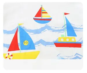Detail of soft cotton knit fabric with colorful cartoon sailboat and wave prints