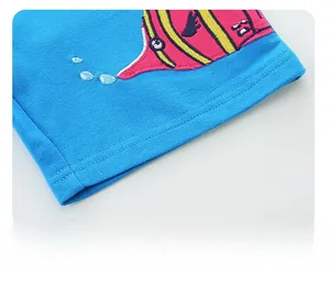 Detailed close-up of boy's blue cotton trousers with colorful cartoon embroidery on the cuff