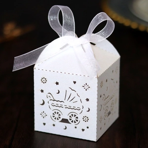 Detail der weiß gelaserten Geschenkbox mit Kinderwagen-Motiv und elegantem Organza-Band