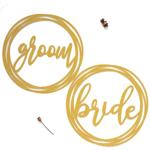 Golden glitter Groom and Bride chair signs with circular floral frames for wedding decor