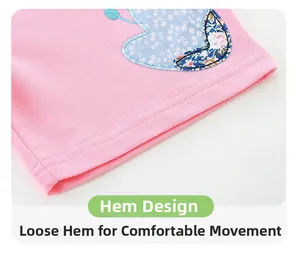 Dettaglio del pantaloncino in maglia rosa con applicazione floreale e cuciture premium