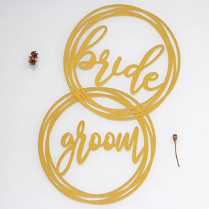 Glittering gold bride and groom chair signs with elegant calligraphy for wedding decor