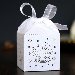 Detail der lasergeschnittenen Gastgeschenkdose mit Kinderwagenmotiv und weißer Schleife