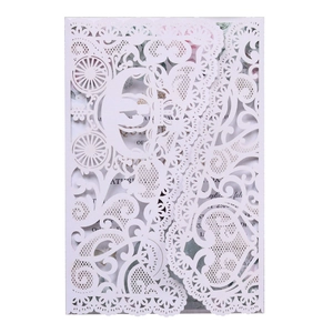 Detailed laser-cut white wedding invitation featuring a carriage design and lace patterns