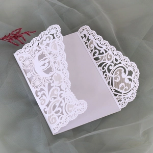 Close-up of laser-cut wedding invitation featuring pumpkin carriage and floral patterns