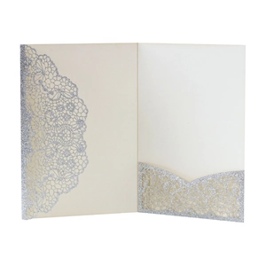 Detail of cream laser-cut invitation card with glitter lace border and pocket design