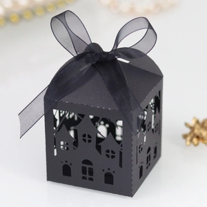 Detail of a laser-cut gothic candy box featuring intricate house cutouts and a black ribbon