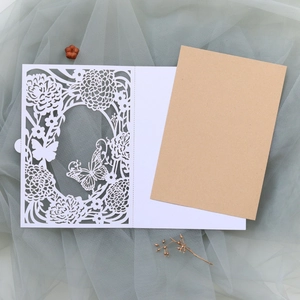 Macro view of laser-cut floral and butterfly invitation card with kraft paper insert