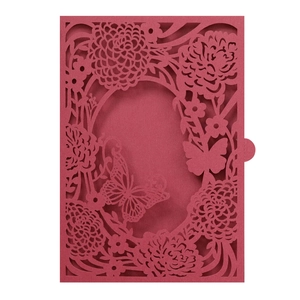 Close-up of laser-cut burgundy invitation card with intricate butterfly and rose pattern