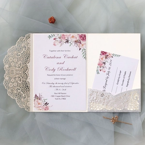 Detail of laser-cut wedding invitation set with floral card and silver glitter pocket