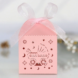 Nahaufnahme einer rosa lasergeschnittenen Kinderwagen-Geschenkbox mit Glanzeffekt und Schleife