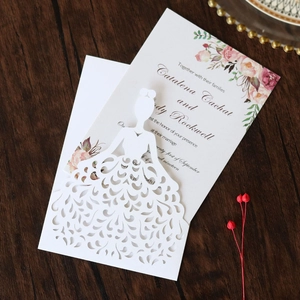 Close-up of laser-cut bridal gown wedding invitation with pink floral inner card details