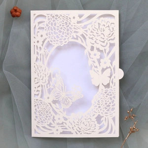 Detailed laser-cut white wedding invitation card with intricate floral and butterfly patterns