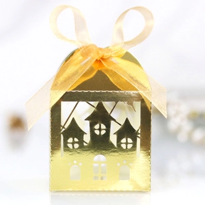 Detail of gold laser-cut house-shaped candy box with star and moon patterns and ribbon